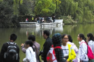 昨日，北京大学，游客在未名湖边游览