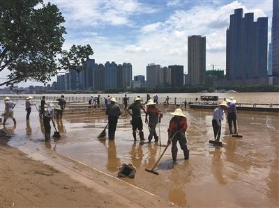 7月7日，工作人员在长沙橘子洲景区内清淤。 新京报记者 孙瑞丽 摄