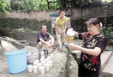 黎婆婆在黄葛古道入口请游人喝茶水。 本报记者 高科 摄